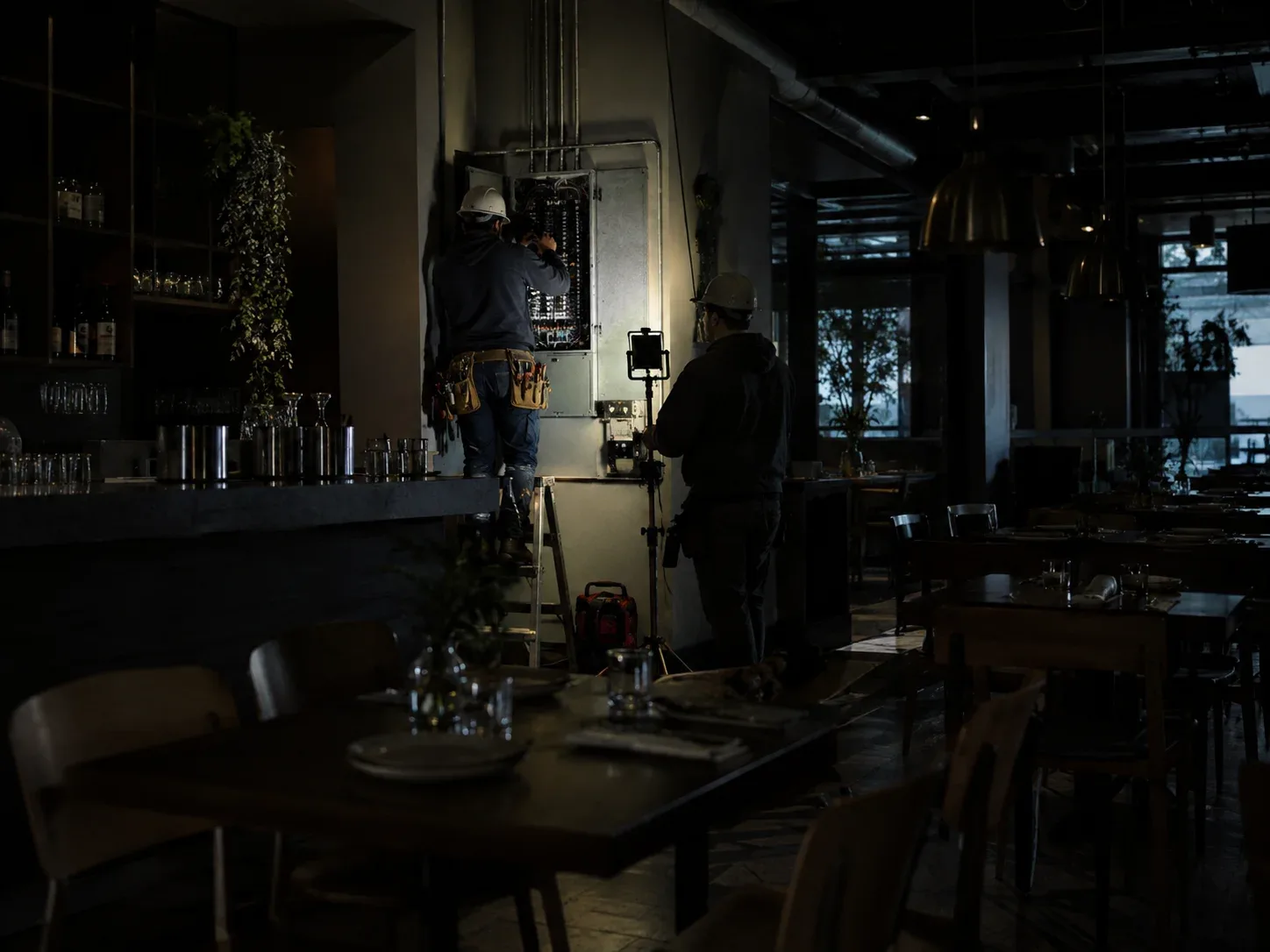 Electrician inspecting commercial electrical distribution equipment after an unexpected power failure