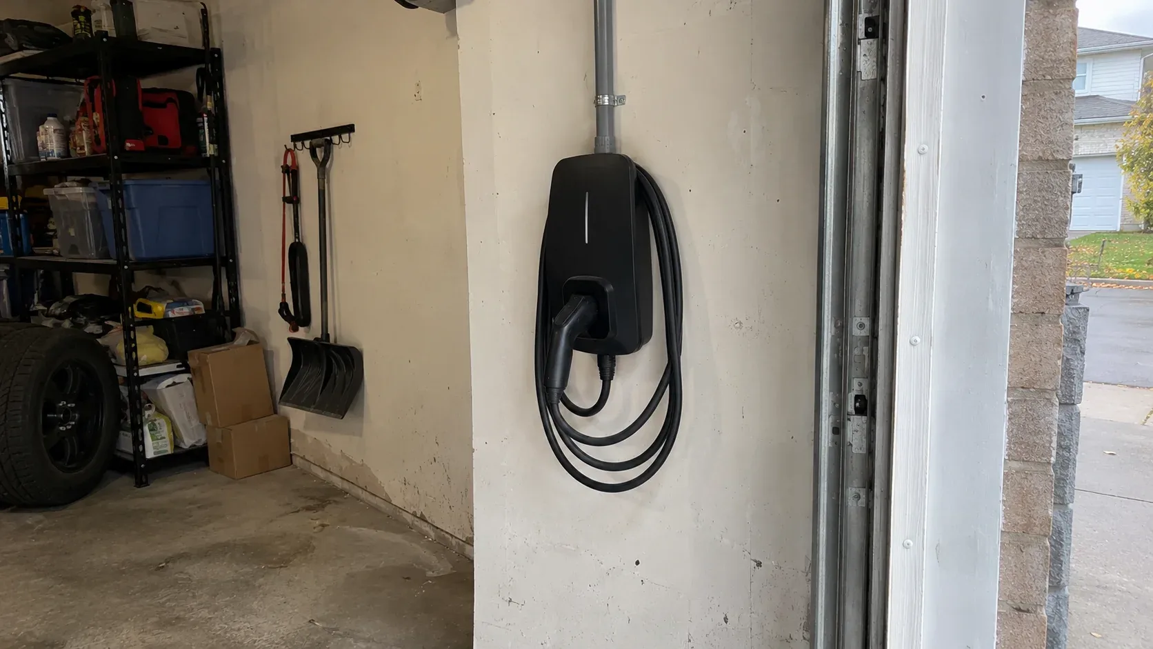Installed Level 2 electric vehicle charger mounted on the wall of a residential garage