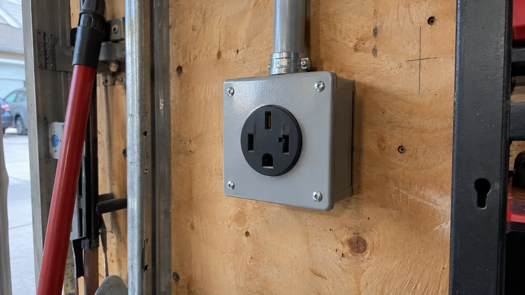 Professionally installed NEMA 14-50 electrical outlet for a portable electric vehicle charger in a garage